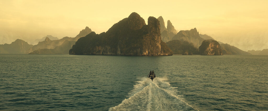 The wakes behind the boat emphasize the scale of Skull Island.