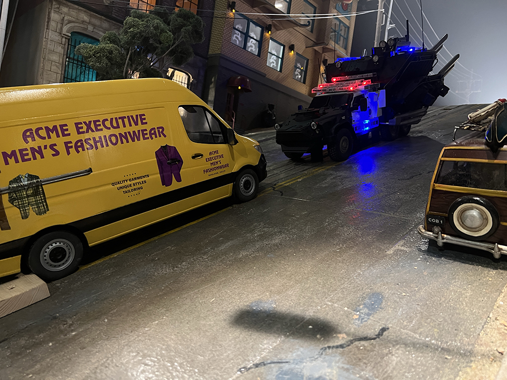 The miniature van and police tanker face off on a model of the streets of SanFrancisco.