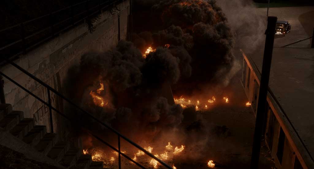 A massive explosion occurs, generating a lot of fire, smoke, embers and debris.